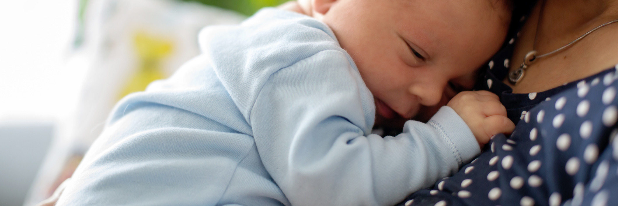 bébé endormi dans les bras de sa maman