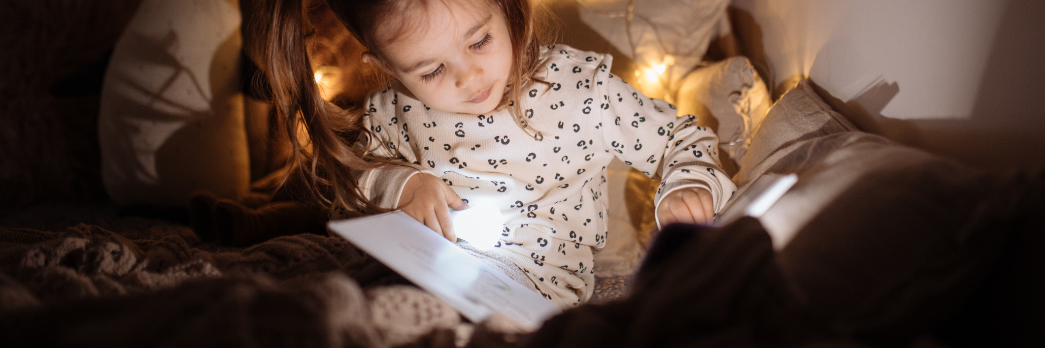 Petite fille lisant au lit