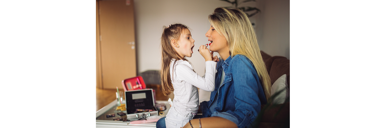 Fillette qui s'amuse à maquiller sa mère
