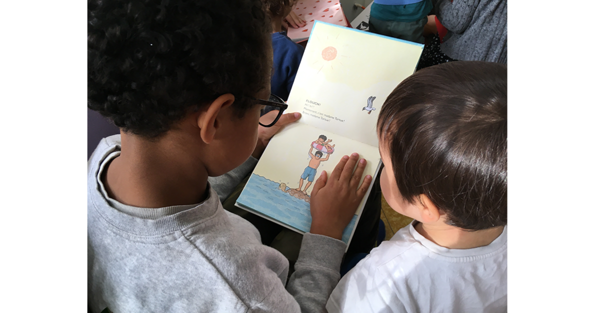 Des enfants de fin de primaire lisent, de façon individualisée, des albums jeunesse à des plus jeunes de maternelle