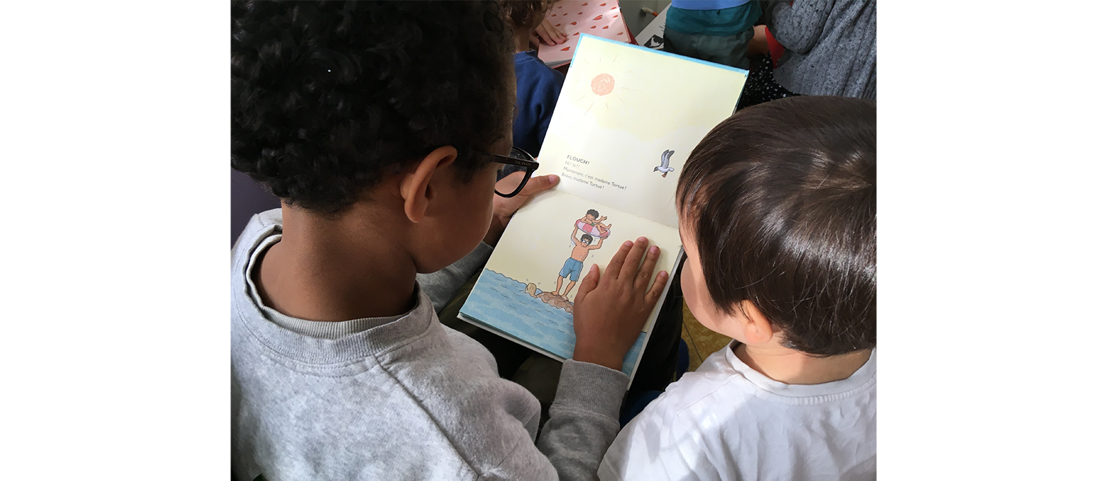 Des enfants de fin de primaire lisent, de façon individualisée, des albums jeunesse à des plus jeunes de maternelle